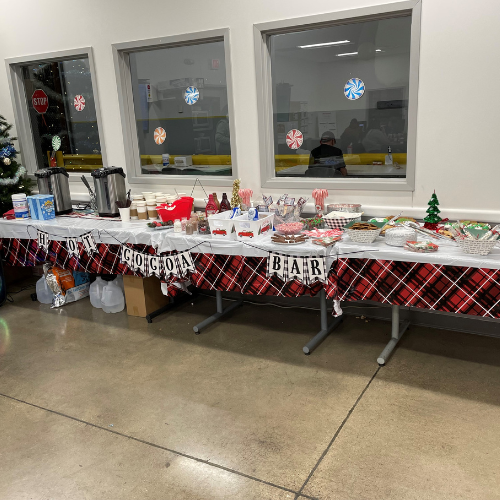 Christmas tree to the left with cocoa and gift wrapping on the table