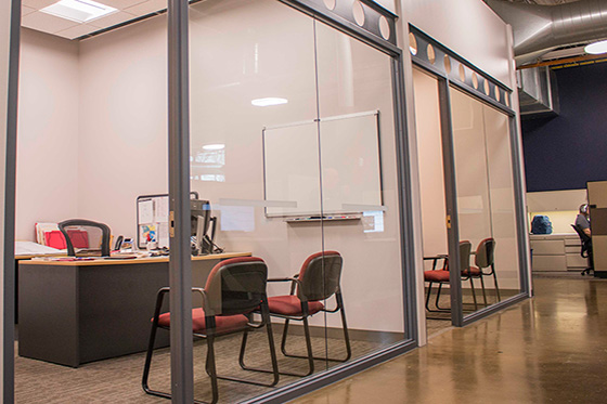 Two glass-front offices with different lighting hues through PoE lighting