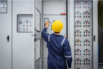 Man with safety hat working on control panel