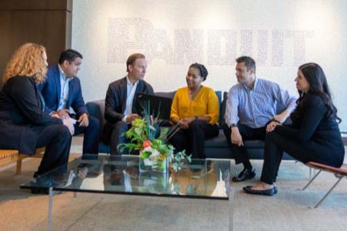 Group of male and female employees and CEO sitting and interacting with each other