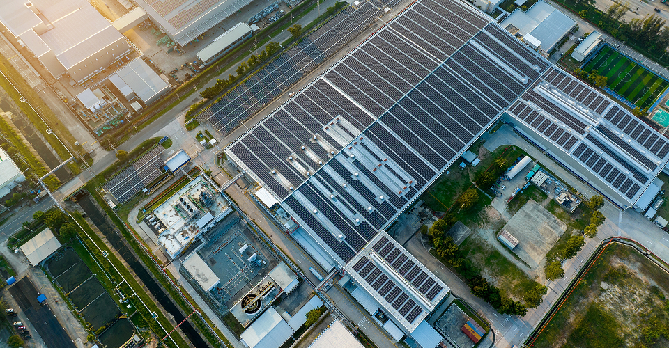 View of an electrified warehouse with solar panels and heat pumps on the roof