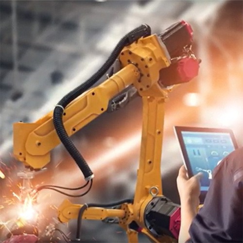 Robotic arm with sparks and a hand holding an electronic tablet