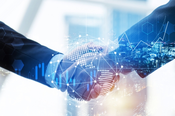 Partners shaking hands with business operations overlayed